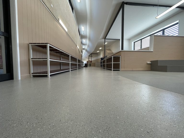 Flake epoxy floor running the length of a fitted out corridor with shelving
