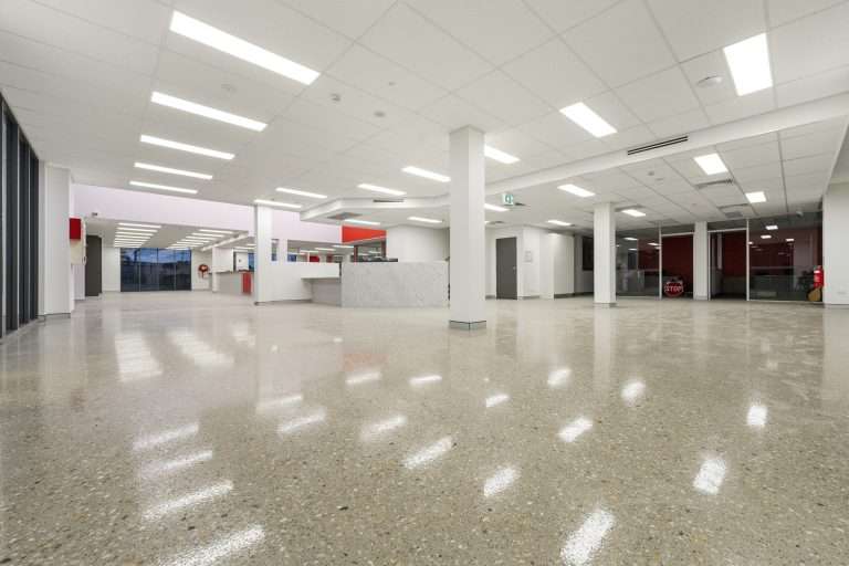 Polished concrete floor across the Isuzu Yatala showroom, with white columns and a service counter at the rear