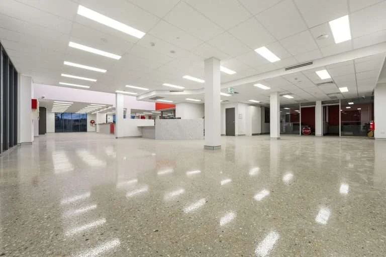 Polished concrete floor across the Isuzu Yatala showroom, with white columns and a service counter at the rear